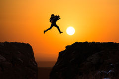 hikers-jumping-silhouette-man-off-cliff-direction-bright-sun-35850780